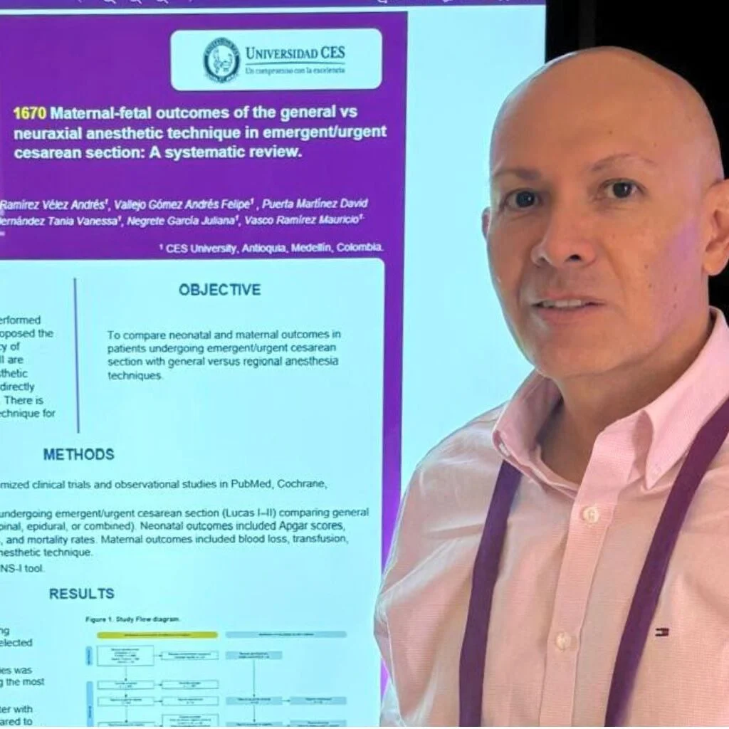 Persona de pie frente a una pantalla que muestra un póster académico de la Universidad CES sobre resultados materno‑fetales y técnicas de anestesia en cesáreas, en un entorno de presentación académica.