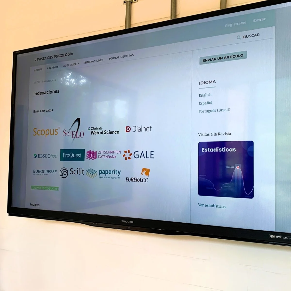 Pantalla digital que muestra la página de indexaciones de la Revista CES Psicología. En el centro aparecen los logotipos de bases de datos e índices académicos como Scopus, SciELO, Web of Science, Dialnet, EBSCOhost, ProQuest y GALE.