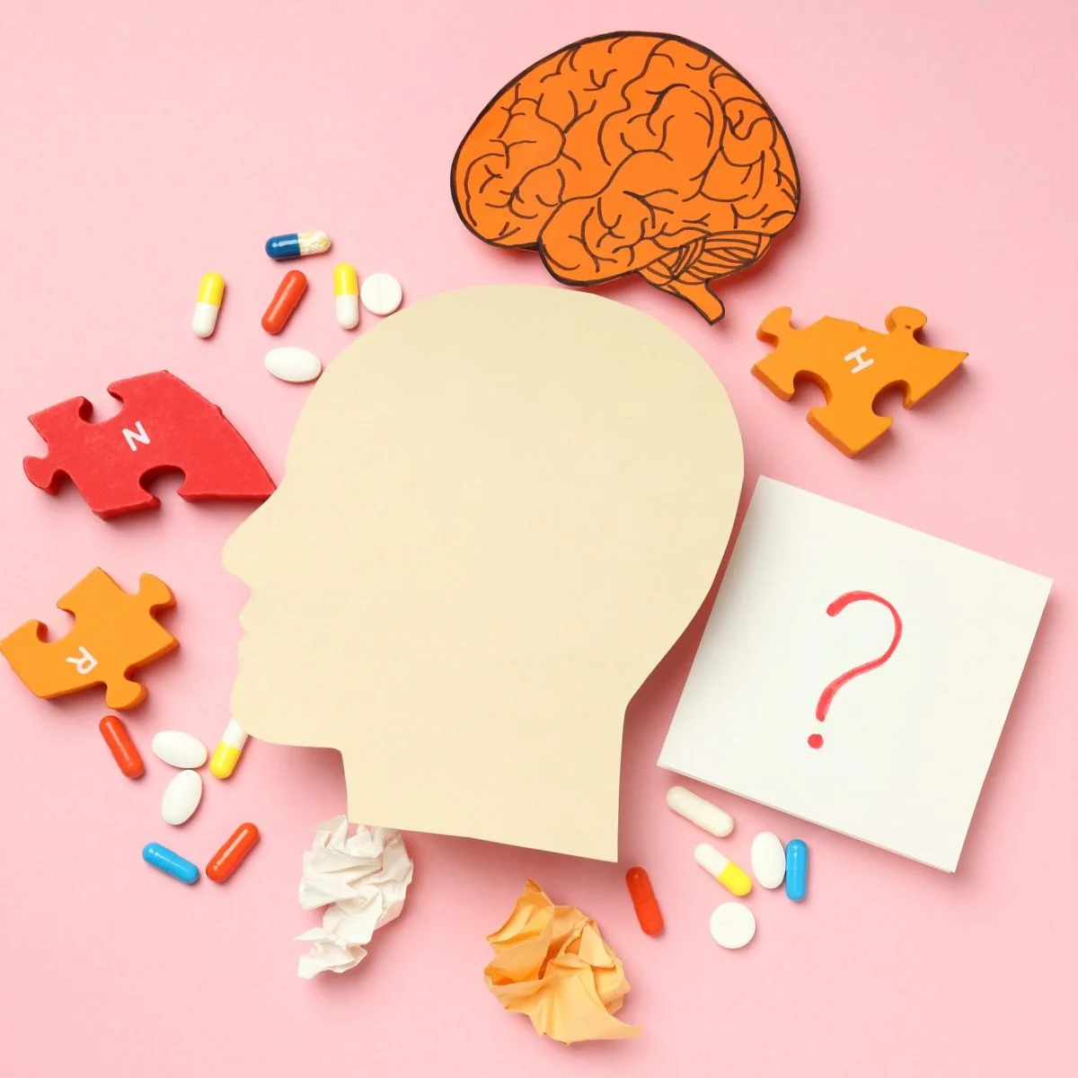 Ilustración conceptual sobre salud cerebral y trastornos neurológicos. Se observa la silueta de una cabeza humana rodeada por piezas de rompecabezas, cápsulas y tabletas, un dibujo de un cerebro y una nota con un signo de interrogación sobre un fondo rosa.