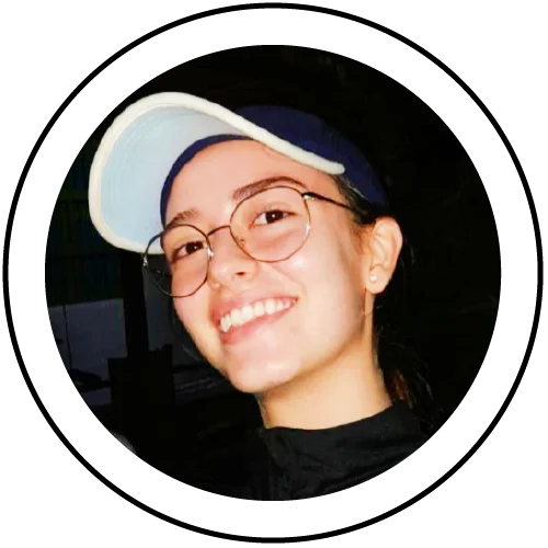 Persona en fotografía tipo retrato, centrada dentro de un marco circular, vistiendo una gorra clara, gafas de montura delgada y una chaqueta oscura, sobre un fondo oscuro.