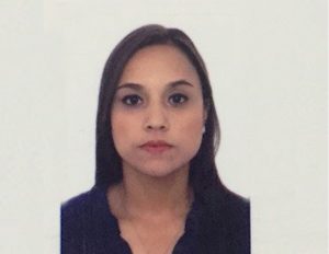 Persona con cabello oscuro y liso, vestida con una blusa negra de escote en V, frente a un fondo blanco liso.