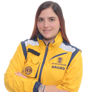 Persona con chaqueta amarilla del DAGRD, con logotipos visibles y brazos cruzados, sobre fondo blanco.