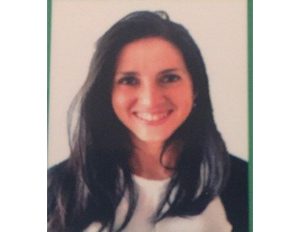 Persona con cabello largo y oscuro viste camiseta clara y chaqueta oscura, en una imagen tipo retrato sobre fondo claro con borde verde.