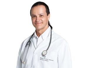 Persona con bata blanca y estetoscopio colgado alrededor del cuello, sobre fondo blanco.